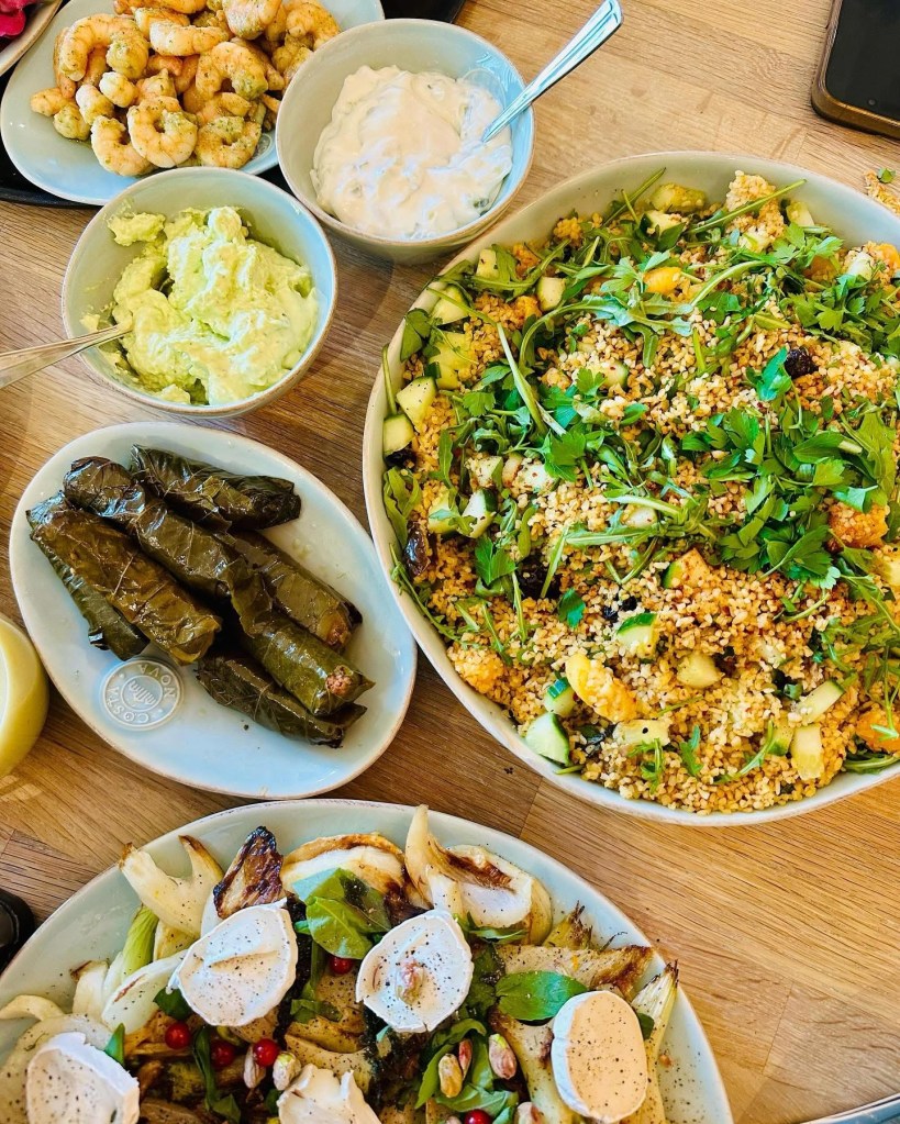 Mesa con mezze, ensaladas y gambas